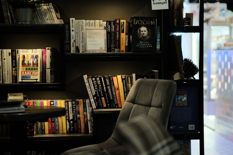 Modern office spot with bookshelf featuring a variety of books and stylish armchair.