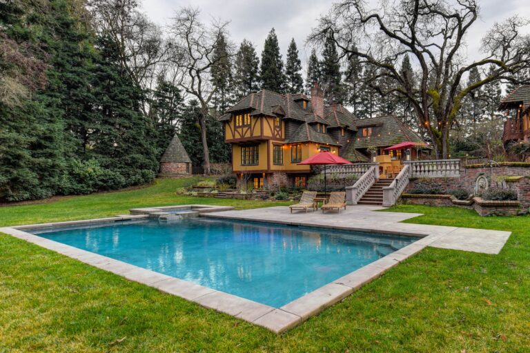 Stunning Tudor-style mansion with a pool, lush garden, and vibrant summer scenery.